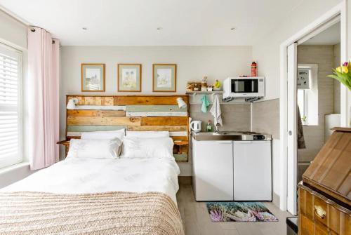 a small bedroom with a bed and a kitchen at Arlington - private room and en-suite in Woking