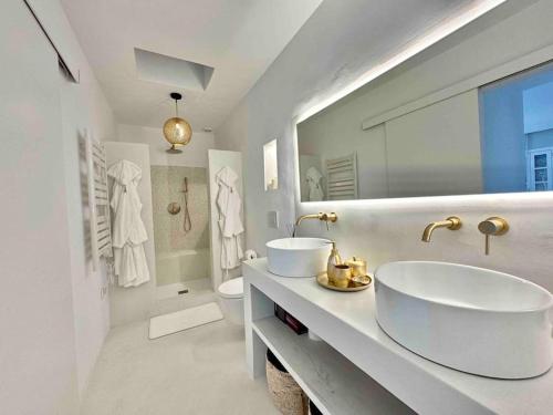 Baño blanco con 2 lavabos y aseo en Mil y un momentos mágicos: Villa con encanto árabe en Marbella