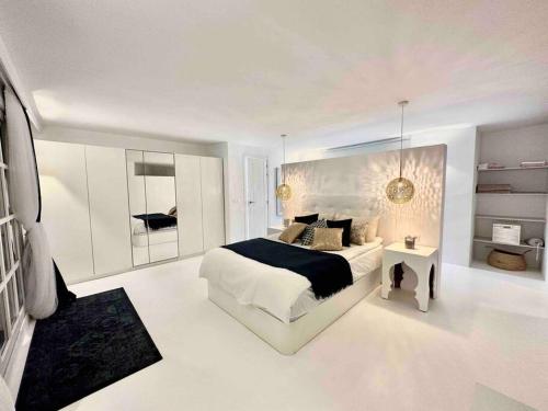 Dormitorio blanco con cama y mesa en Mil y un momentos mágicos: Villa con encanto árabe en Marbella