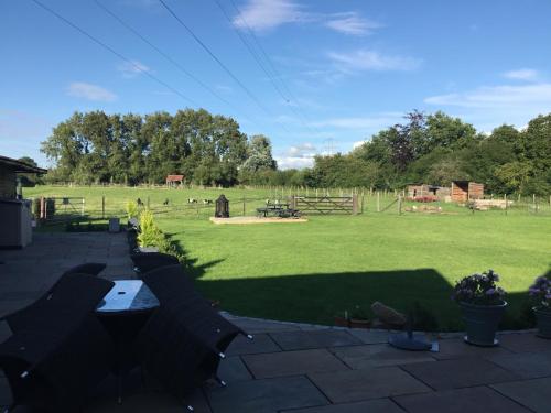 a backyard with a field of grass and a fence at Oaks Barn in Chinnor