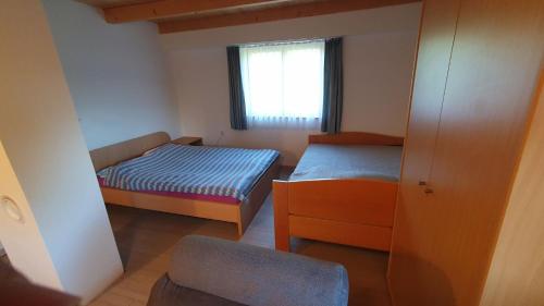 Habitación pequeña con 2 camas y ventana en Hiška ob gozdu, en Polzela