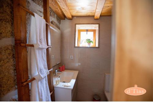 a bathroom with a sink and a toilet and a window at Casa das Tias in Baltar