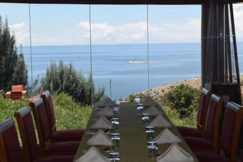 a table with chairs and a view of the ocean at Allpa Tika Lodge in Amantani