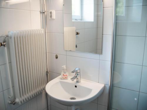 een badkamer met een wastafel en een spiegel bij Vassbo Logi & Event in Falun