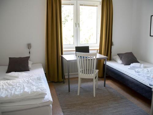 法倫的住宿－Vassbo Logi & Event，客房设有两张床、一张桌子和一把椅子。