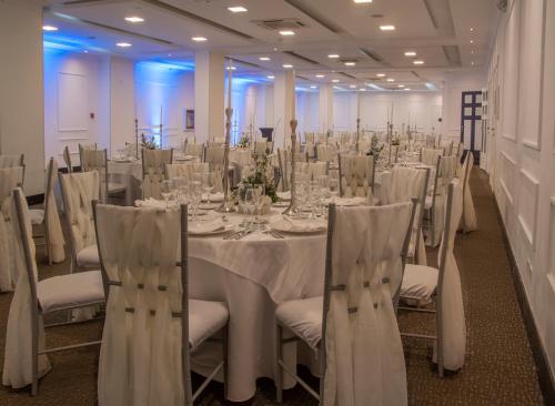 a room with a long table with white tables and chairs at Dann Carlton Quito in Quito