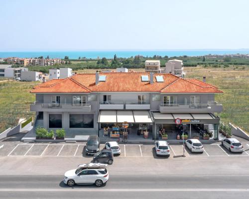 a building with cars parked in a parking lot at Calives Premium Stay in Kalivia Poligirou