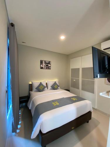 a bedroom with a large bed and a flat screen tv at Ghurfati Hotel Wedana in Jakarta
