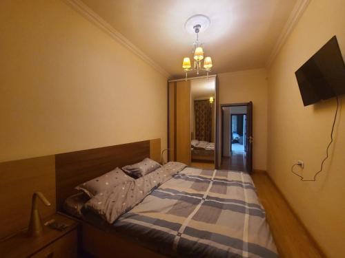 Schlafzimmer mit einem Bett und einem Kronleuchter in der Unterkunft Best Apartment In The City Center in Yerevan