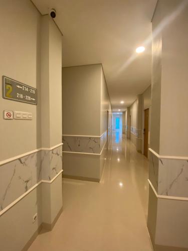 an empty hallway in a hospital with a sign on the wall at Ghurfati Hotel Wedana in Jakarta