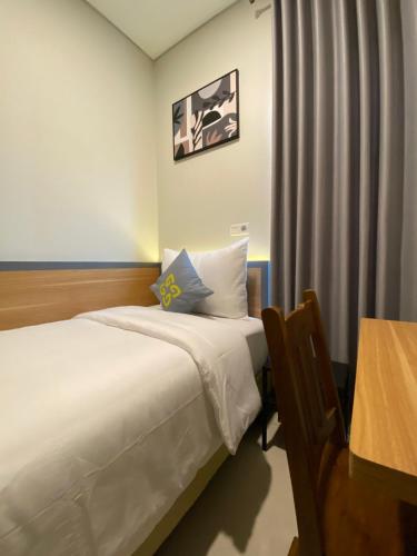 a hotel room with a bed and a table at Ghurfati Hotel Wedana in Jakarta
