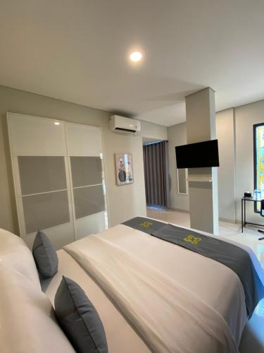 a bedroom with a large bed and a flat screen tv at Ghurfati Hotel Wedana in Jakarta