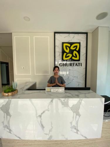 a man sitting at a counter in a room at Ghurfati Hotel Wedana in Jakarta