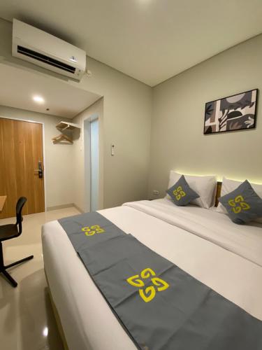 a bedroom with a bed with yellow symbols on it at Ghurfati Hotel Wedana in Jakarta