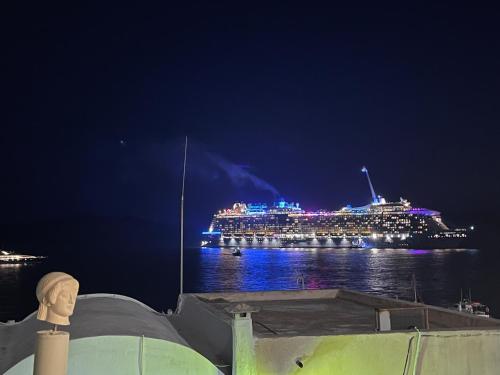 a cruise ship on the water at night at Phaedra and Ariadni - Caldera Sea and Volcano Sea View 2 joined Houses in the Old Port of Fira, Santorini 4br-2ba-2livingr in Fira