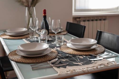 a table with plates and glasses and a bottle of wine at Domus Montebello in Rome
