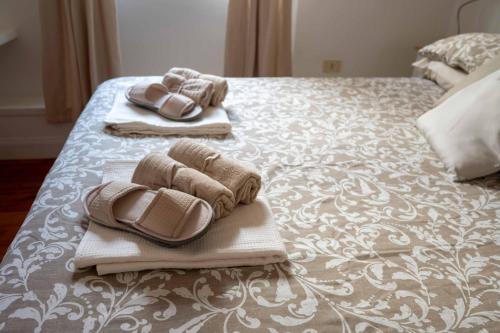 a bed with towels and slippers on top of it at Domus Montebello in Rome