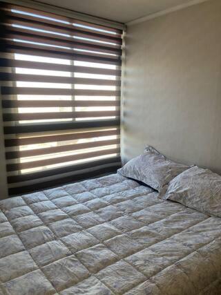 a bedroom with a bed in front of a window at Departamento Carmen & Argomedo in Santiago