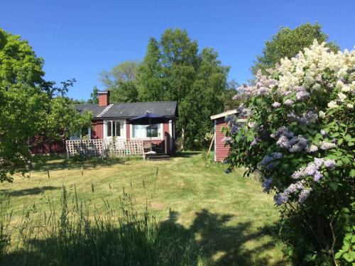 a cottage in the middle of a yard with flowers at Semesterhus i Stockholms skärgård, Runmarö. in Nämdö