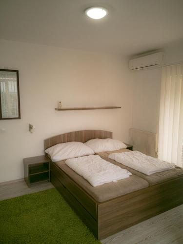 um quarto com 2 camas e um tapete verde em Moderný Apartmán v Podhájskej em Podhájska
