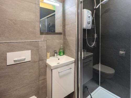 a bathroom with a white sink and a shower at Windermere Crescent in Windermere