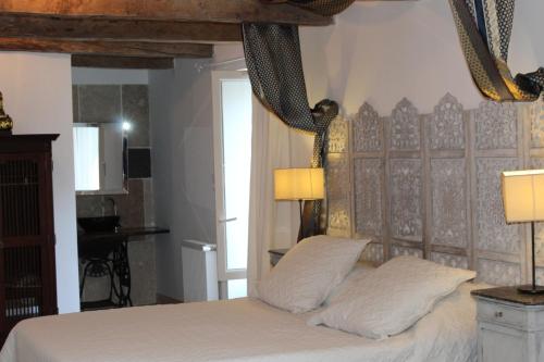 a bedroom with a bed with white sheets and two lamps at La maison Cayré in Mirandol-Bourgnounac