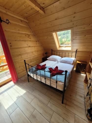 a bedroom with a bed in a log cabin at Osada Stasiowe Chaty in Stronie Śląskie