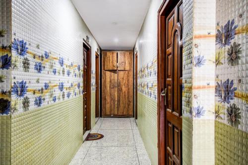 a hallway with colorful tile walls and a wooden door at OYO Flagship The Rest in Gauripur