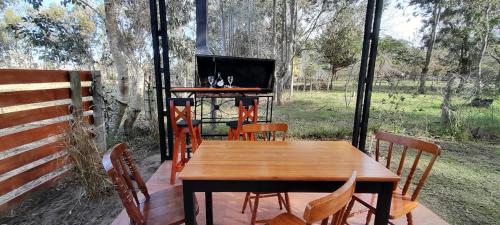 a wooden table and chairs on a porch with a television at EL DESPERTAR in Nueva Palmira