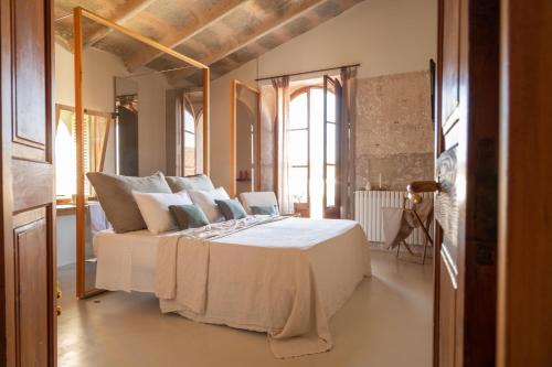 a bedroom with a large bed with white sheets and pillows at Can Moio Turismo de Interior in Montuiri