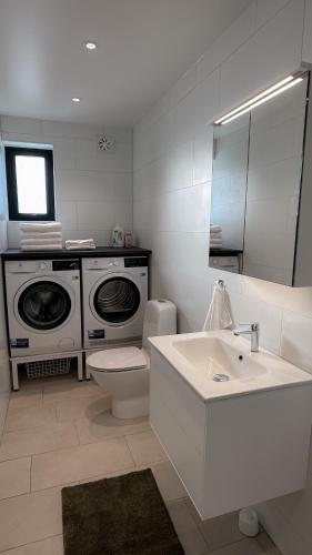 a bathroom with a washing machine and a sink at Strandviks semesterboende in Halmstad
