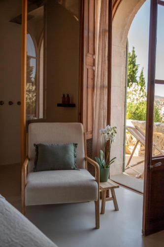 a bedroom with a chair and a door to a balcony at Can Moio Turismo de Interior in Montuiri