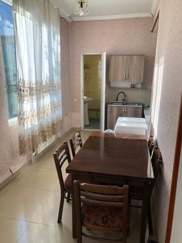 bakuriani home في باكورياني: غرفة طعام مع طاولة وكراسي في مطبخ