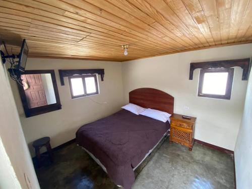 um quarto com uma cama e um tecto de madeira em Hotel del Ferrocarril em Quetzaltenango