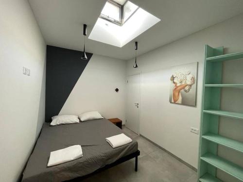 um quarto com uma cama e uma clarabóia em Roni’s place em Bnei Yehuda