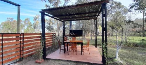 a pergola with a table and chairs on a wooden deck at EL DESPERTAR in Nueva Palmira