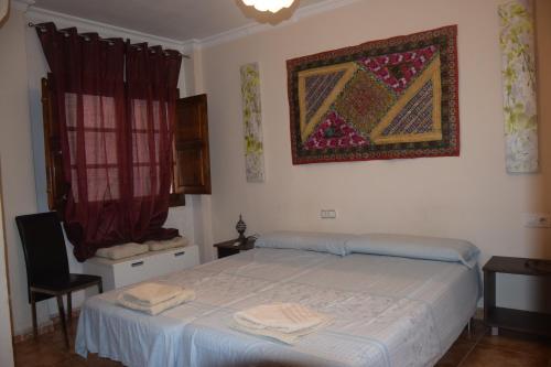 sypialnia z łóżkiem i dywanem na ścianie w obiekcie Centro de Granada w Grenadzie