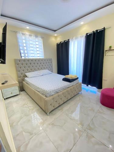 a bedroom with a bed in a room with black curtains at Acogedor apartamento in Santiago de los Caballeros