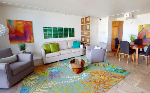ホノルルにあるArtsy 32nd Floor Condo with Modern Furnishings & Gorgeous Ocean Views condoのソファとテーブルのあるリビングルーム
