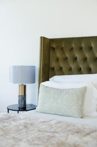 a bed with a pillow and a lamp on a table at Palácio do Visconde - The Coffee Experience in Lisbon