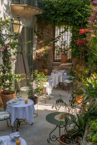 a patio with tables and chairs and plants at Can Moio Turismo de Interior in Montuiri