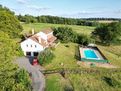 une vue aérienne d'une maison et d'une piscine dans l'établissement Maison spacieuse avec piscine privée, wifi et parking à Lanouaille - FR-1-616-335, à Lanouaille