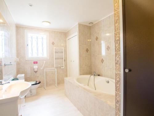 LanouailleにあるMaison spacieuse avec piscine privée, wifi et parking à Lanouaille - FR-1-616-335の浴槽、トイレ、洗面台を備えたバスルーム