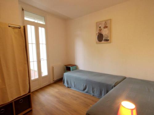 une chambre avec deux lits et une fenêtre dans l'établissement Appartement tout confort 3 pièces avec terrasse et wifi, face aux Thermes de Luchon - FR-1-313-225, à Luchon