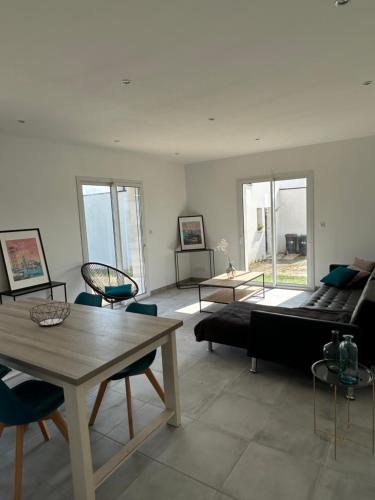 un salon avec un canapé, une table et des chaises dans l'établissement Maison neuve, à Plouguerneau