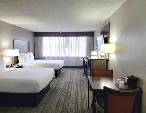 勞雷爾的住宿－羅瑞爾品質套房酒店，酒店客房设有两张床和一张桌子。