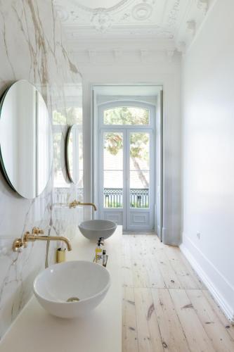 a white bathroom with a sink and a mirror at Palácio do Visconde - The Coffee Experience in Lisbon