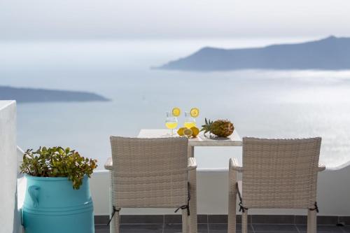 a table with two chairs and a table with drinks at Remvi Suites in Firostefani