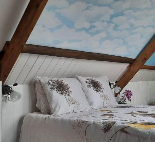 ein Bett mit zwei Kissen darüber in der Unterkunft Rustiek Andijk in Andijk