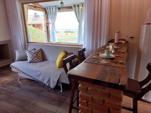 阿尤魯奧卡的住宿－Chalé Mirante Da Guapiara，一间带桌子、沙发和窗户的用餐室
